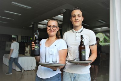 Eine Schülerin und 1 Schüler der 5Hb präsentieren ihr selbst gebrautes Bier.